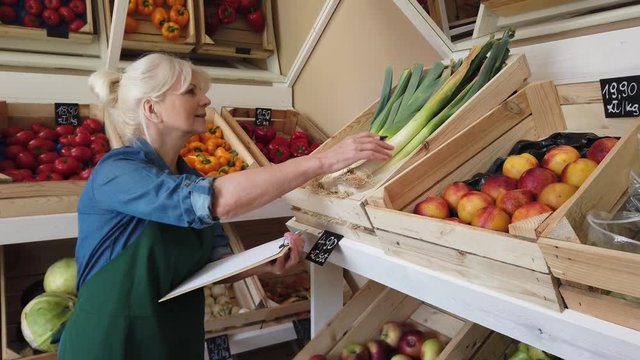 Senior woman working in small grocery store
