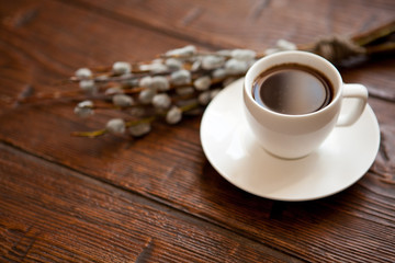 Pussy-willow branch wreath with buds and cup of tea coffee