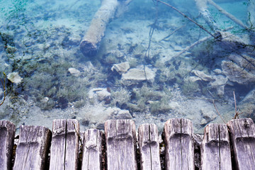 Fototapeta premium View at crystal clear blue water from wooden boardwalk