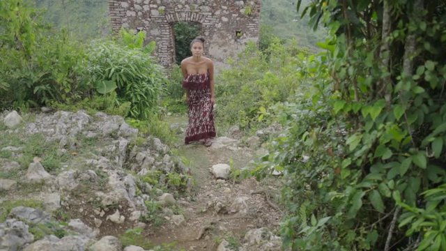 Exotic Young Woman Walks from Ancient Building toward Camera in Citadel Laferriere, Haiti