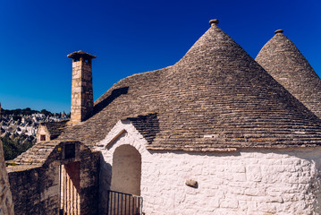 Stone tiles cover the roofs of the trulli in Alberobello, an Italian city to visit on a trip to...