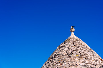 Fototapeta na wymiar Stone tiles cover the roofs of the trulli in Alberobello, an Italian city to visit on a trip to Italy.