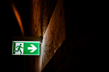 Emergency exit sign illuminated with dark background.
