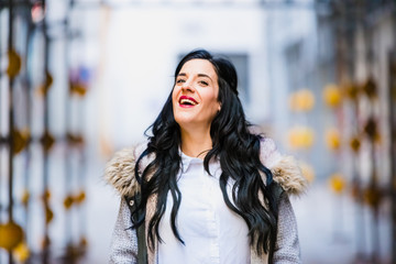 Middle-aged woman smiling and laughing happily walking through the city.