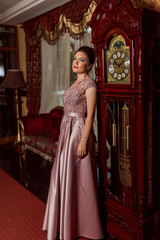 Obraz premium Young beautiful girl in pink luxury dress for the prom night