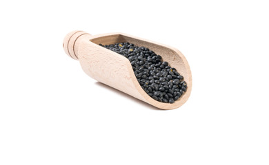black lentils beluga  in wooden scoop isolated on white background. nutrition. bio. natural food ingredient.front view.
