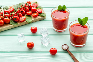 tomato juice, spinach and ice for summer healthy drink on mint green wooden background