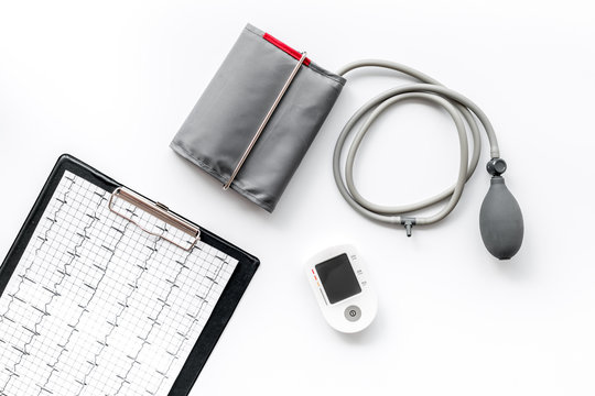 pulsimeter and cardiogram on the desk of the doctor for diagnostics of cardiac disease on white background top view