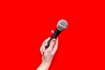 blogger, journalist or musician work space with microphone in hand on red background top view space for text