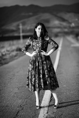 Young girl in the middle of road in colorful dress with flowers