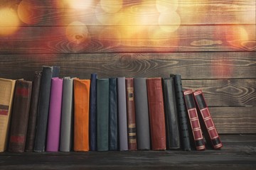 Ancient books in a row on wooden background