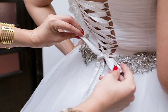 The Bride In A White Wedding Dress With A Corset And A Silver Belt.