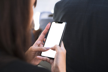 Woman hand using smart phone at airlane with blank screen mobile phone for graphic display .
