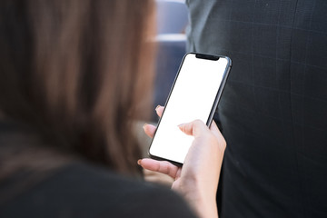 Woman hand using smart phone at airlane with blank screen mobile phone for graphic display .
