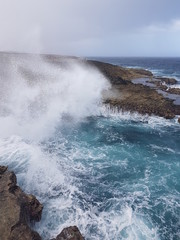 blue waves crashing on the shore of curacao