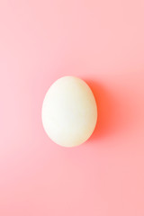 White Easter egg on yellow pastel background. Happy Easter concept. Minimal concept. Flat lay. Top view.