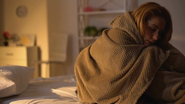 Sick female lying in bed covering with blanket, fever symptom, flu weakness