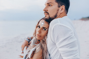 Obraz premium beautiful young couple on the beach at sunset. love and relationships concept