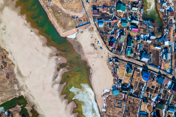 Aerial photography of a small village with villas and cottages, river, beach,forest and roads. Helicopter drone shot