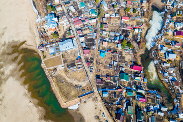 Obraz premium Aerial photography of a small village with villas and cottages, river, beach,forest and roads. Helicopter drone shot