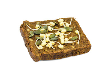 A piece of dark bread with sprouted mung beans and pumpkin seeds isolated on a white background.