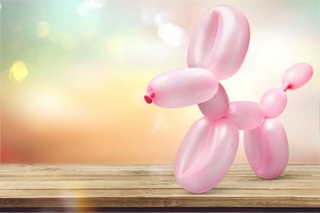 Pink balloon in form of dog on background