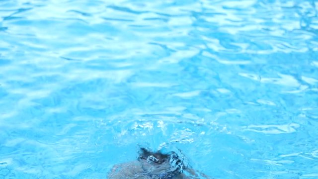 Older man going underwater, re-emerging and smiling to camera