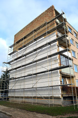 Insulating old flat house wall with white polystyrene