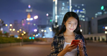 Fototapeta premium Woman use of smart phone city night