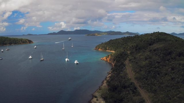 Aerial Forward: Magnificent Coast Line of Norman Island with Boats Scattered in Norman Island, British Virgin Islands