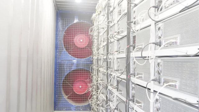 Special storage white servers room for farms of mining cryptocurrency working process with huge rotating coolers which are cooling the equipment.