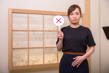 バツを持つ居酒屋スタッフ