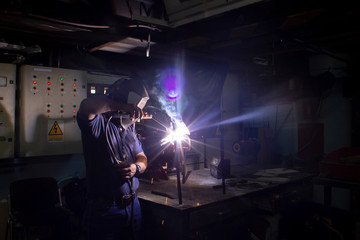 Welding technician, carrying out welding work in the workshop