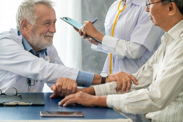 Senior male doctor talking to elder man patient in the hospital office. Medical healthcare and...