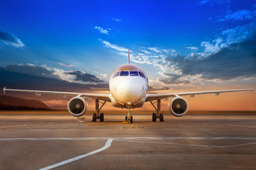 Fototapeta na wymiar modern aircraft on an airfield against a sunset