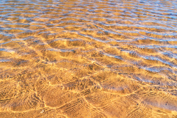 Clear smooth wave beach with sand texture background.