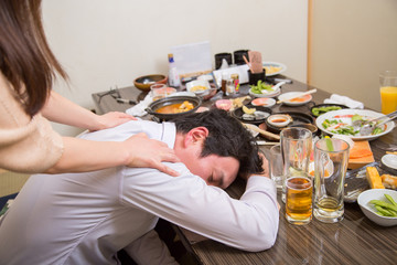 酔いつぶれる男性を介抱する