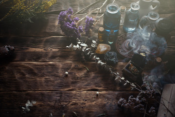 Various dried herbs and bottles on a brown wooden table. Herbal medicine, alternative medicine...