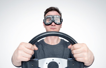 Confident man in stylish goggles with steering wheel, car driver concept