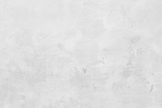 Close-up of a stone or concrete wall painted in white, paint slightly peeled off. Full frame texture background in black and white.