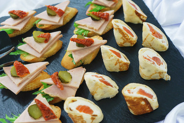 Tapas, canaps, sandwiches, rolls with red fish prepared for the visitors of the event. 