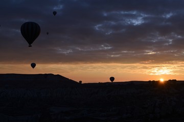 Sunrise and balloons. Beautiful background of the balloon and the sunset.Cappadocia. Turkey. Göreme. Nevşehir. Türkiye. 8. 04. 2019. Balloons flying over the rocky landscape in Cappadocia Turkey. View