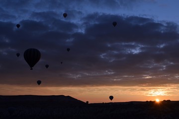 Sunrise and balloons. Beautiful background of the balloon and the sunset.Cappadocia. Turkey. Göreme. Nevşehir. Türkiye. 8. 04. 2019. Balloons flying over the rocky landscape in Cappadocia Turkey. View