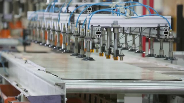 manipulator with vacuum suction cups puts sheet on conveyor