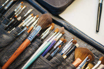 Workplace make-up artist special brushes to create an image and make-up in in a leather case on the table. 
