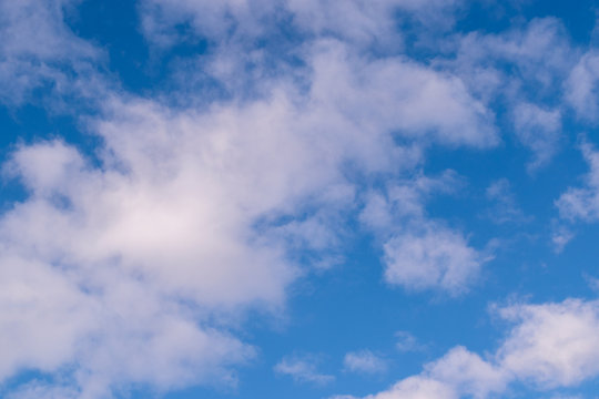 Blue sky in sunny day with white puffy clouds. Natural background