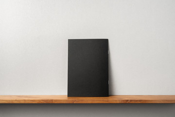back view of black magazine stand on bookshelf
