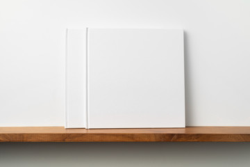 2 white square notebook on bookshelf