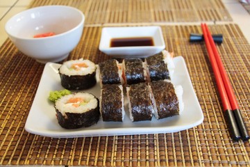 Set of sushi rolls makizushi, also known as norimaki or makimono, with cucumber and salmon on a bamboo mat known as a makisu. Sushi, Japanese cuisine, Food and drink concept.