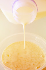 pouring milk in bowl of flakes breakfast